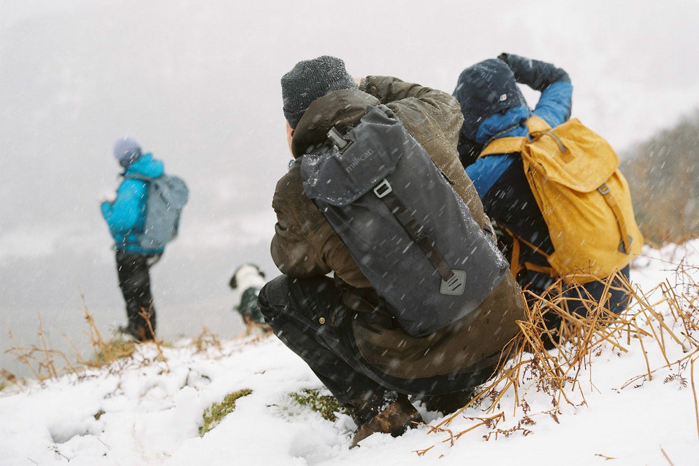 People wearing Millican backpacks in snowy weather