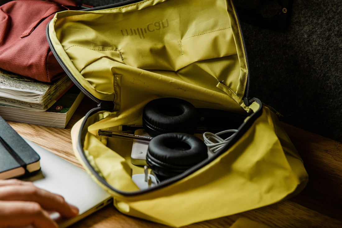 Open travel bag with headphones and essentials