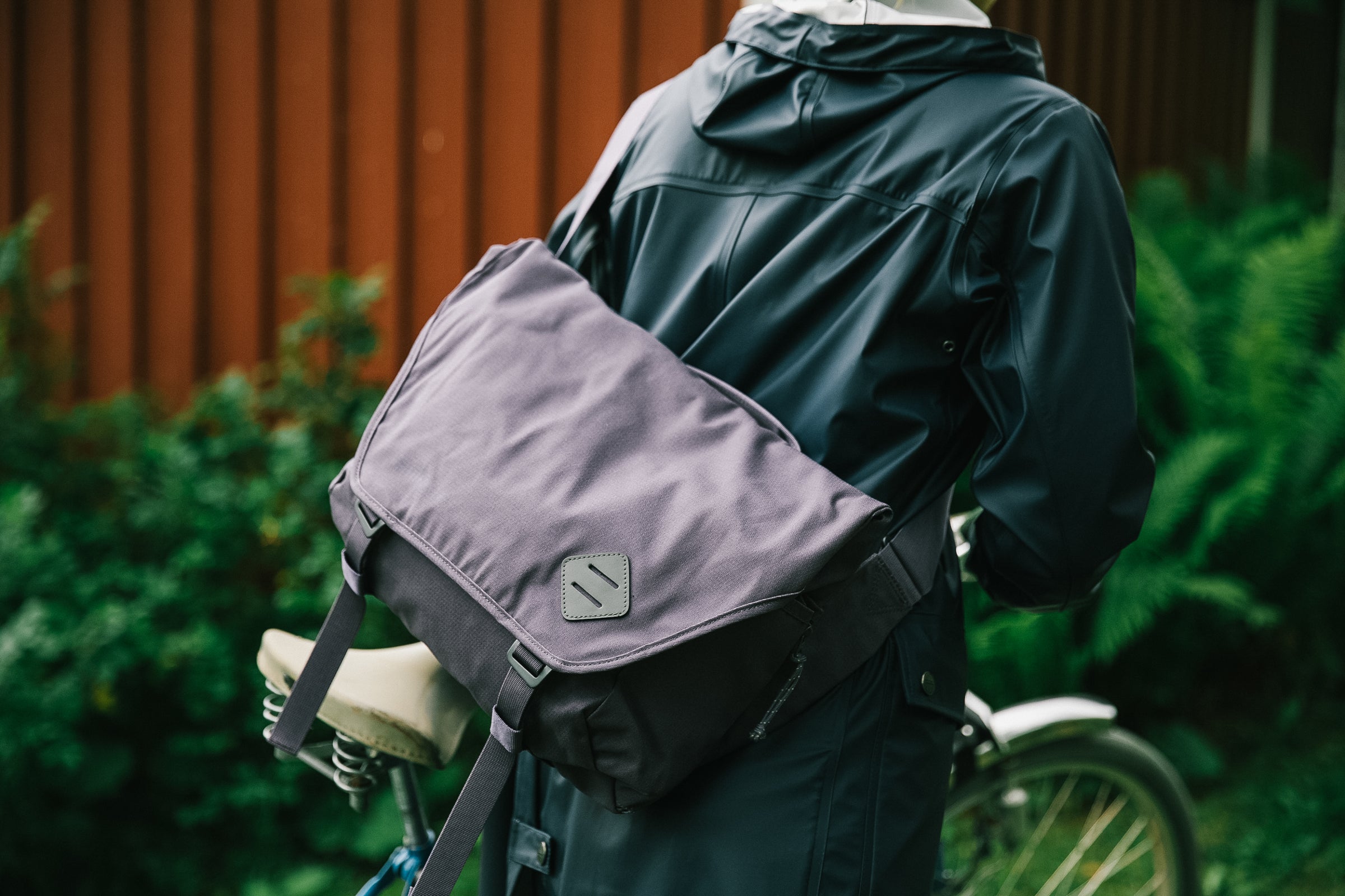 Person cycling with a grey Millican messenger bag