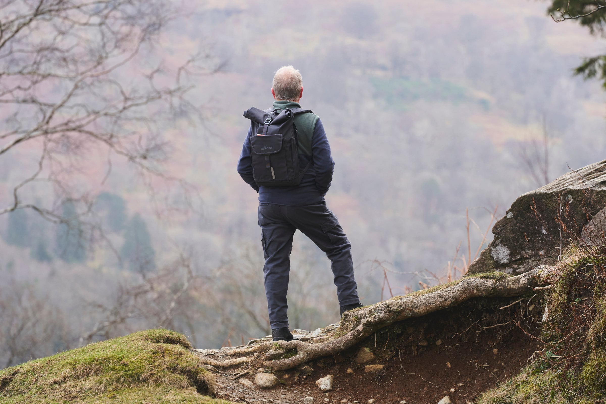 Person with a backpack standing on a rocky outcrop